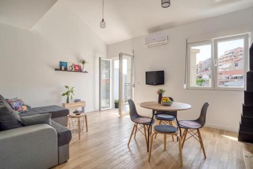 un salon avec un canapé, une table et des chaises dans l'établissement Magi-Family Rooftop Apartment Budva, à Budva