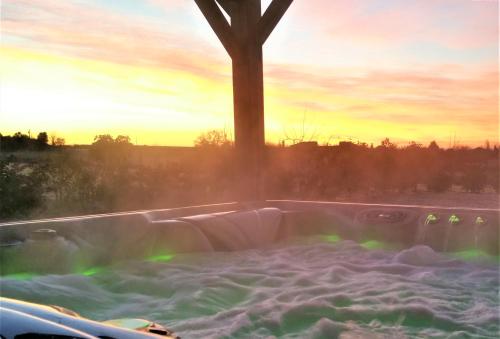 a jacuzzi tub with the sunset in the background at Ets CAPMASIL - chambre 1920 in Virac