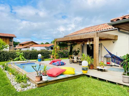 une cour arrière avec une piscine et une maison dans l'établissement Villa Madiba 4 étoiles tout confort à 7 min de la plage, à Seignosse