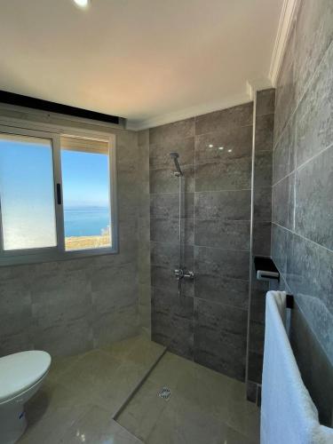 a bathroom with a shower and a toilet and a sink at Hiba apartments in Fnidek