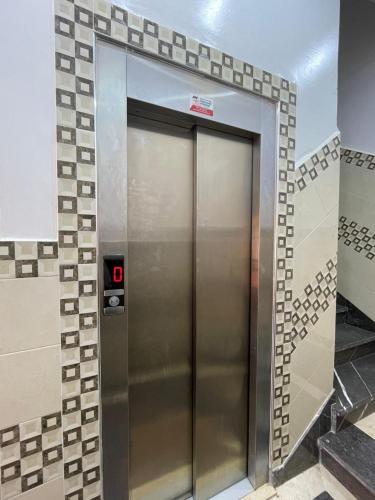 a elevator in a room with a tile wall at Hiba apartments in Fnidek