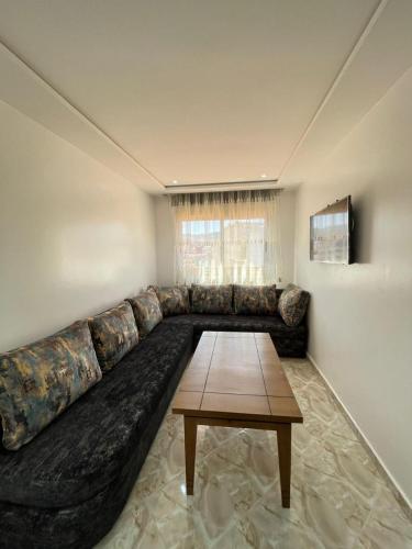 a large couch in a living room with a table at Hiba apartments in Fnidek
