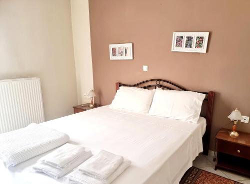 a bedroom with a bed with white sheets and pillows at Dione by Open City in Dhimitsana