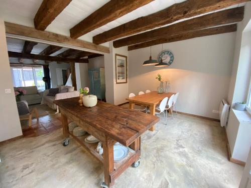 Il comprend une cuisine et un salon avec une table en bois. dans l'établissement Maison de la Chapelle, à Villeréal