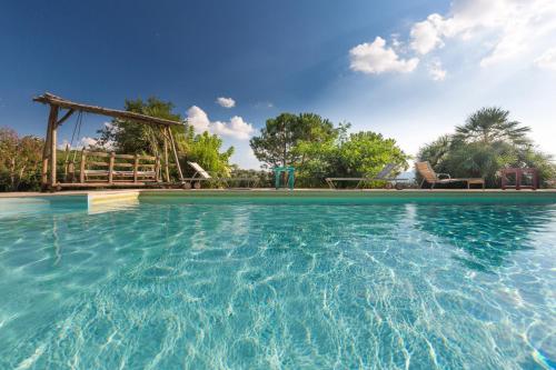 una piscina con tobogán y un parque infantil en Villa Mazzini by Mmega, en Lucignano