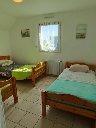 une chambre avec deux lits et une fenêtre dans l'établissement NOUVELLE VILLA d'EMERAUDE PROCHE MER, à Saint-Méloir-des-Ondes