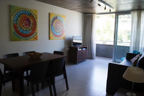 a dining room with a table and chairs and a window at CINCO - Departamentos in La Plata