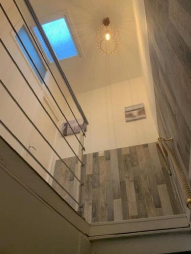 Cette chambre est dotée d'un escalier, d'une fenêtre et d'un plafond. dans l'établissement Maison Frères Prêcheurs, à La Rochelle