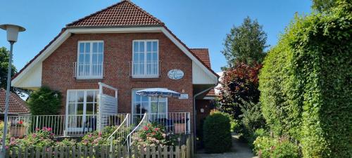 a brick house with an umbrella in front of it at Rosa Canina W2 in Kellenhusen