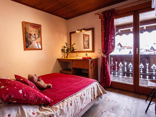 a teddy bear laying on a bed in a bedroom at Appartement au centre Les Gets, 3 étoiles, 3 pers, proche télécabines et école de ski - FR-1-671-6 in Les Gets