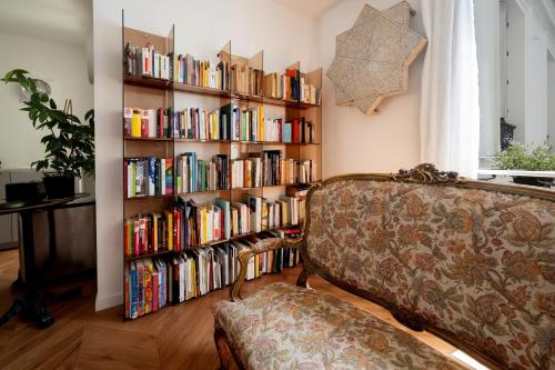 un salon avec une étagère remplie de livres dans l'établissement Appartement Ottomane - Welkeys, à Paris