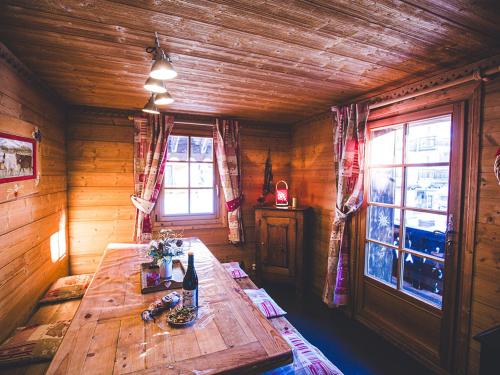 Cette chambre en bois dispose d'une table et de fenêtres en bois. dans l'établissement Appartement cosy 3 étoiles, 3 chambres, 2 salles de bains, centre village, proche télécabines et école de ski - FR-1-671-11, aux Gets