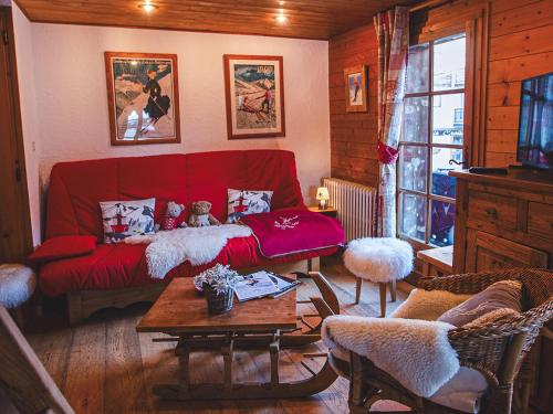 un salon avec un canapé rouge et une table dans l'établissement Charmant Appt aux Gets avec Balcon, Cheminée et Wi-Fi – Près des Télécabines ! - FR-1-671-71, aux Gets
