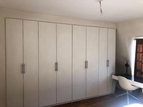 a room with white cabinets and a desk at Villa Joia Molitor - Roland Garros in Boulogne-Billancourt