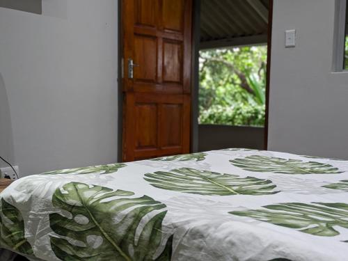 a bedroom with a bed with a green and white blanket at Amapondo in Port St Johns