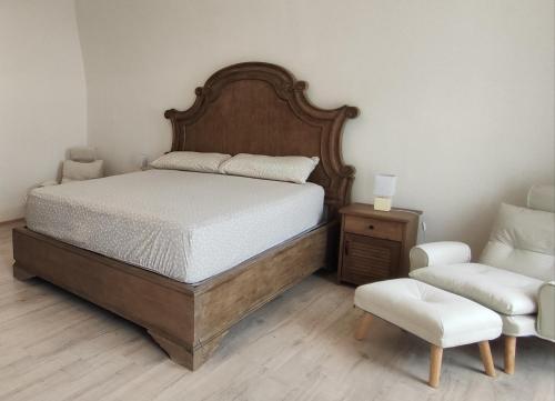a bedroom with a large bed and a chair at Penzión Rosenau in Rožňava