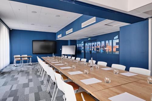 a large conference room with a long table and a screen at Appart Hotel Odalys City Marseille Centre Euromed in Marseille