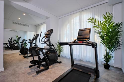 a gym with several treadmills and a laptop at Appart Hotel Odalys City Marseille Centre Euromed in Marseille
