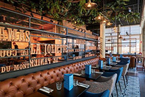 a restaurant with tables and a leather couch at Appart Hotel Odalys City Marseille Centre Euromed in Marseille