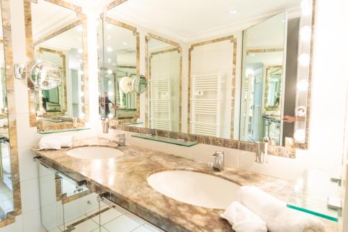 deux lavabos dans une salle de bain avec deux miroirs dans l'établissement Le Clochet du Cap D'Antibes Pavillion de 690m2 Tennis Piscine Spa Plage, à Juan-les-Pins