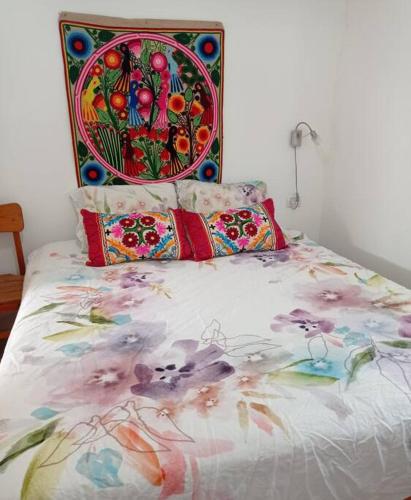 a bed with a colorful blanket and pillows on it at דירה לחופשה משפחתית ליד הכנרת in Tel Kazir