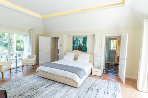- une chambre avec un grand lit dans une pièce dotée de fenêtres dans l'établissement Le Clochet du Cap D'Antibes Pavillion de 690m2 Tennis Piscine Spa Plage, à Juan-les-Pins
