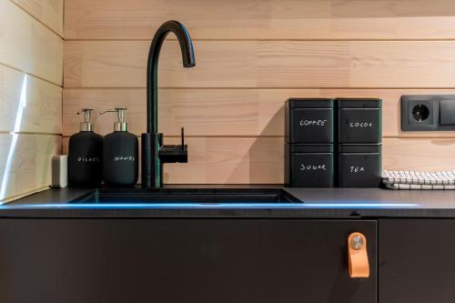 a kitchen counter with a sink and a faucet at Chic Sauna Cabin Near the Sea - SULIN Cabin Nº03 in Tsitre