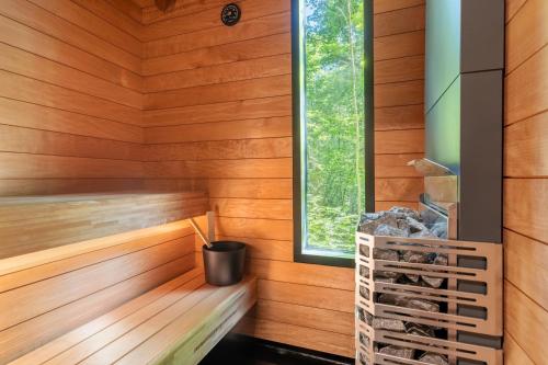 a sauna with wood paneling and a window at Chic Sauna Cabin Near the Sea - SULIN Cabin Nº03 in Tsitre