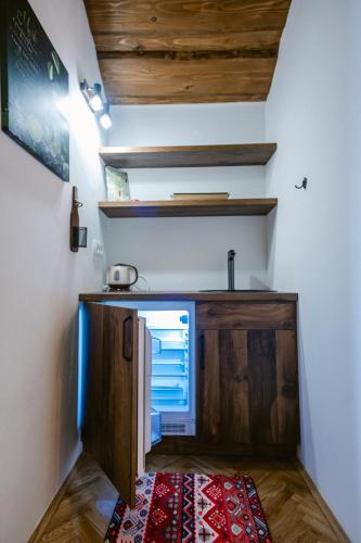 a kitchen with wooden cabinets and a rug on the floor at Holiday House Zrinski with Pool, Sauna & Jacuzzi in Lepoglava
