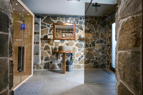 a stone bathroom with a sink and a mirror at Holiday House Zrinski with Pool, Sauna & Jacuzzi in Lepoglava