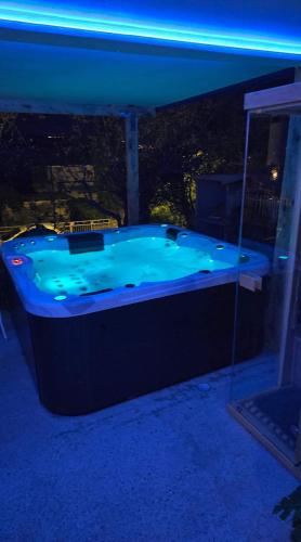 a jacuzzi tub with a view of a city at night at Adriatic SPA Apartment in Selce