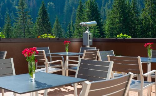 a patio with tables and chairs with a view of the mountains at Wellness Hotel Repiska in Demanovska Dolina