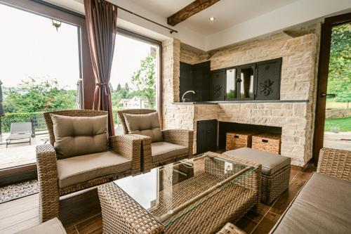 a living room with two chairs and a fireplace at Holiday House Zrinski with Pool, Sauna & Jacuzzi in Lepoglava