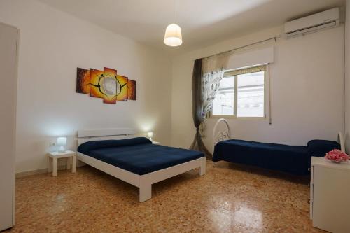 a bedroom with two beds and a window at Casa Tribi a 250 mt dalla spiaggia di Specchiarica di San Pietro in Bevagna in Torre Colimena