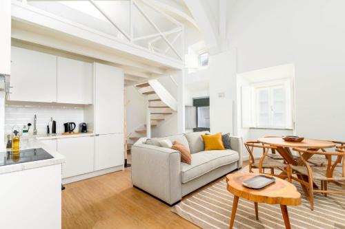 a living room with a couch and a table at Limehome Evora Largo dos Penedos in Évora