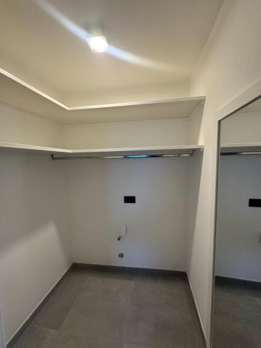 an empty room with a white wall and a mirror at Casa Mimosa in Ischia