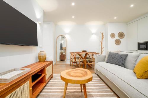 a living room with a couch and a table at Limehome Evora Largo dos Penedos in Évora