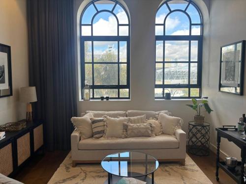 a living room with a couch and three windows at Provincial Heritage CBD-Geelong in Geelong