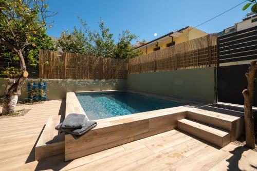 a swimming pool in a backyard with a wooden fence at City Cottage - Kalamata Villas in Kalamata