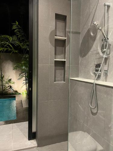 a bathroom with a shower with a glass door at Brand New! Private Room near Canggu Surfing Beaches in Canggu