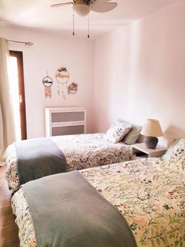 a bedroom with two beds and a ceiling fan at Habitación en apartamento in Port Saplaya
