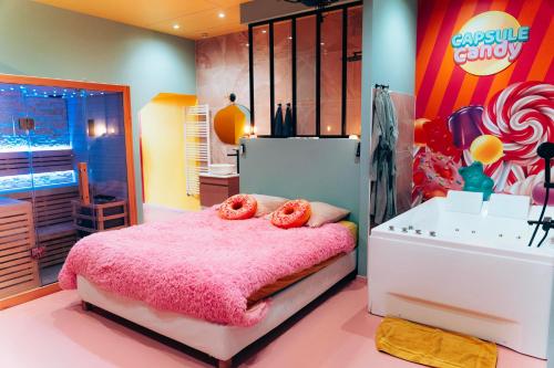a bedroom with a pink bed with two donuts on it at Capsule Bonbon - Balneo - Sauna - Billard - Nintendo Switch in Douai