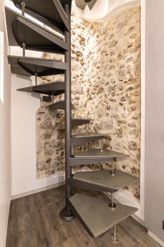 a spiral staircase in a room with a stone wall at Lago 21 - Garden Terrace & Lake view in Pastrengo
