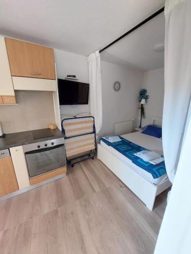 a small bedroom with a bed and a kitchen at Apartman-Cottage Grgec in Jelsa