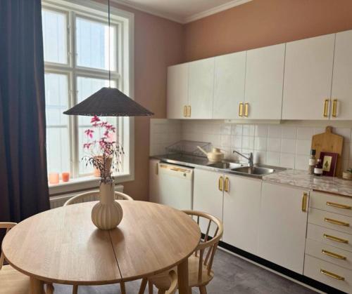 a kitchen with a table with a vase on it at Eksjö Stadshotell in Eksjö