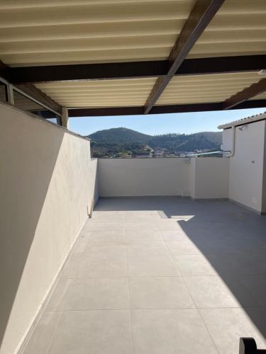 an empty balcony with a view of a mountain at Apartamento aconchegante no centro in Baependi