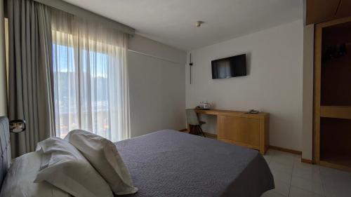 a bedroom with a bed and a large window at hotel garni Santa Caterina in Orta San Giulio