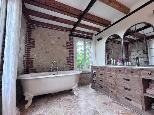 La grande salle de bains est pourvue d'une baignoire et de deux lavabos. dans l'établissement Exceptional 5 bedroom house near the beach, à Trouville-sur-Mer