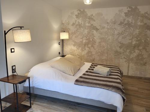a bedroom with a bed and a table with two lamps at Chez Onna in Theneuil