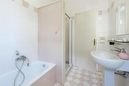 a white bathroom with a sink and a tub and a toilet at Golden Luxe - Roman Luxury Villa in the Sea in Camaiore